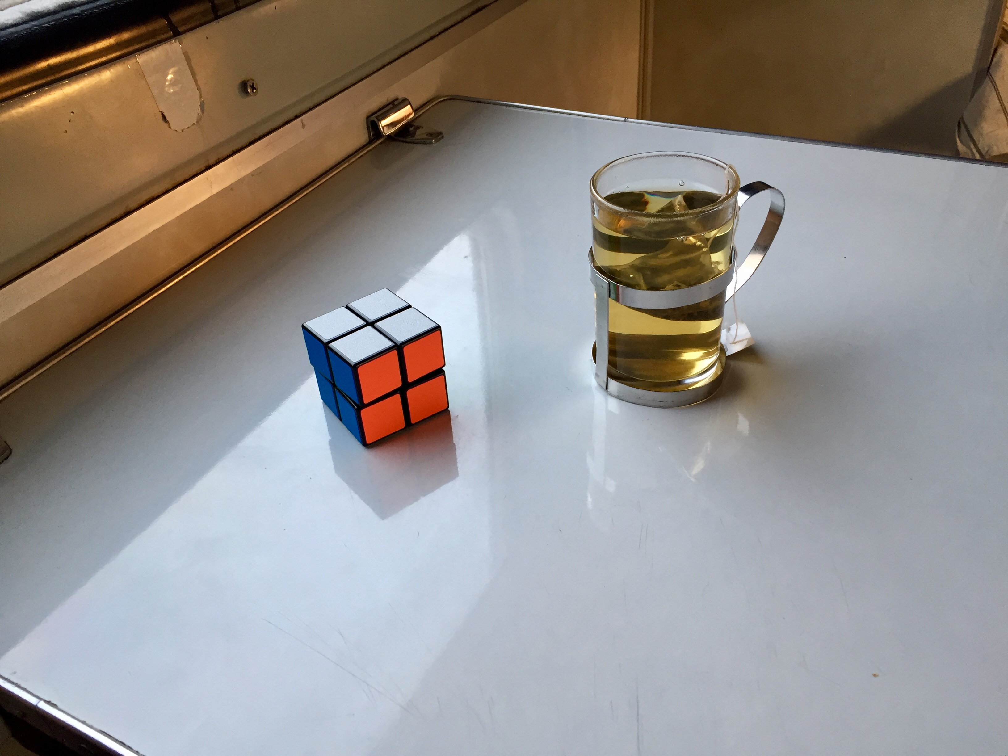 Стол, стакан и кубик Рубика.